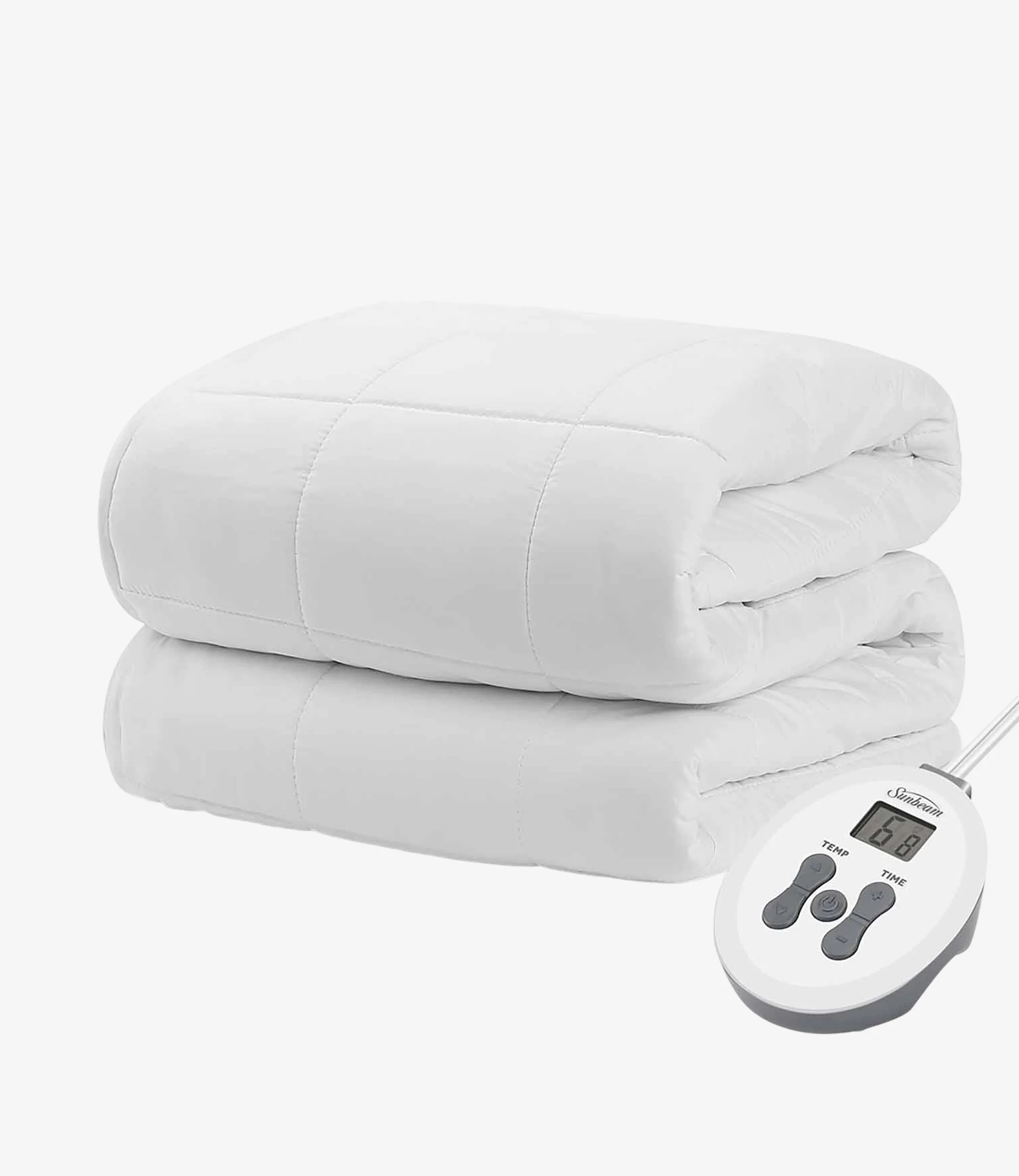 A neatly folded white electric blanket with a quilted pattern lies next to a digital remote control showing temperature settings, conveying warmth and comfort.
